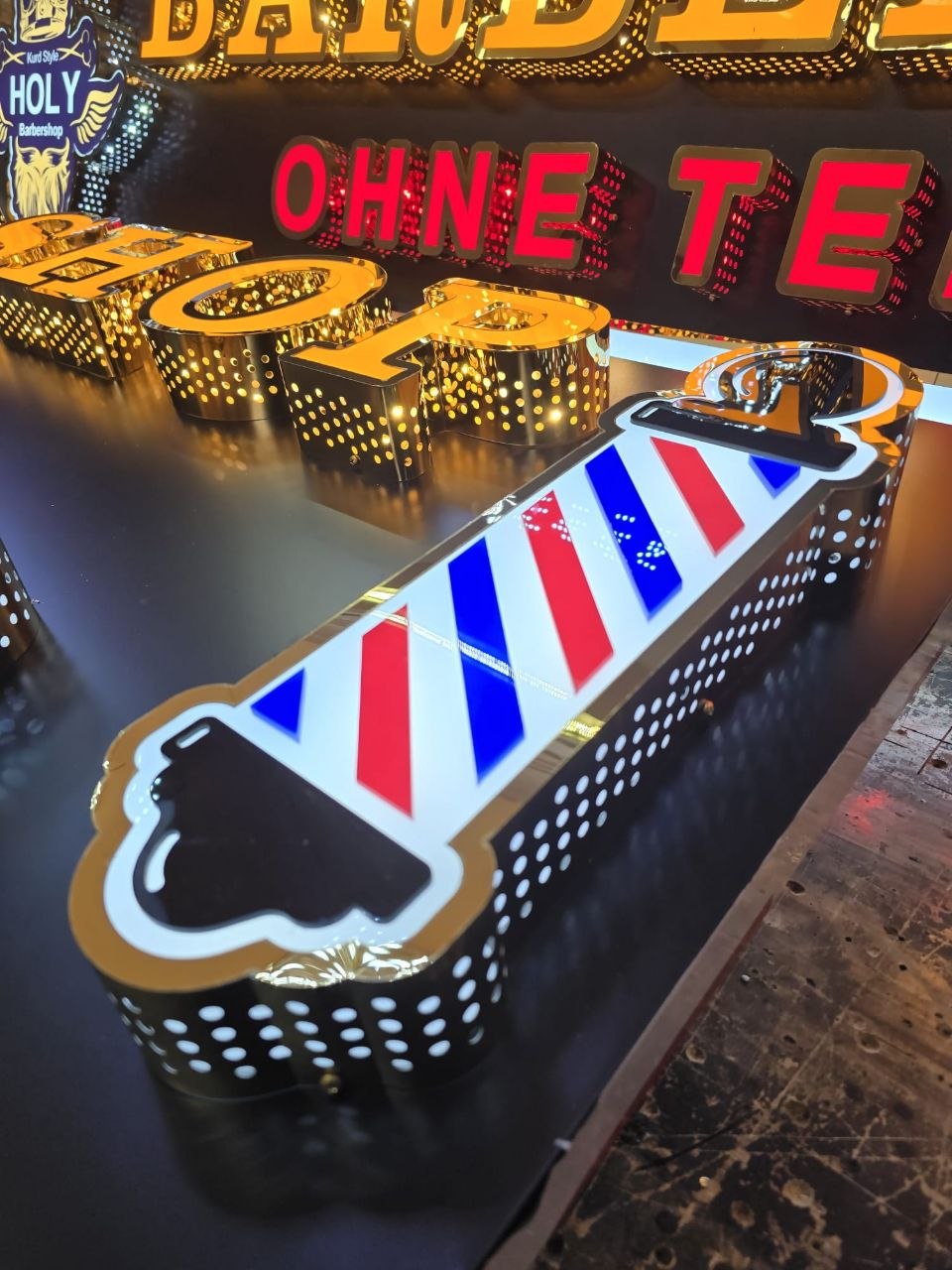 Holy Barbershop — gouden geperforeerde letters in de werkplaats